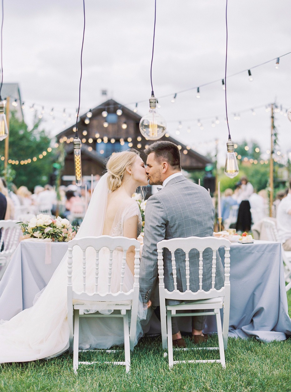 wedding kiss shared at the sweetheart table
