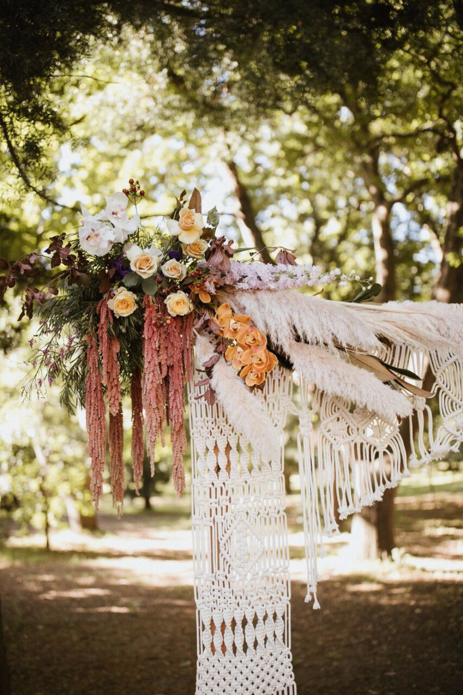 Macrame ceremony backdrop with florals