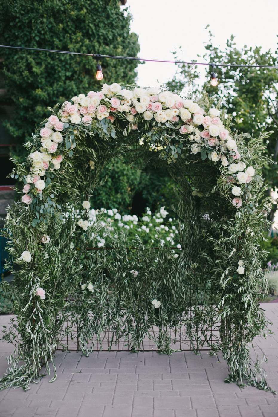 white and blush and greenery wedding arch