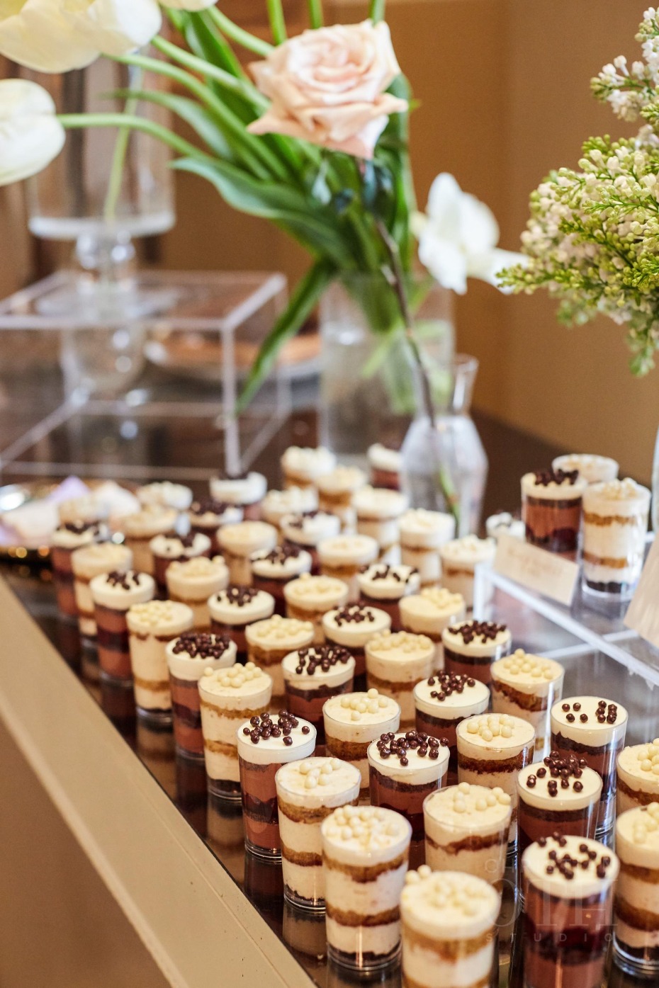 Elegant dessert display with layered treats and fresh flowers