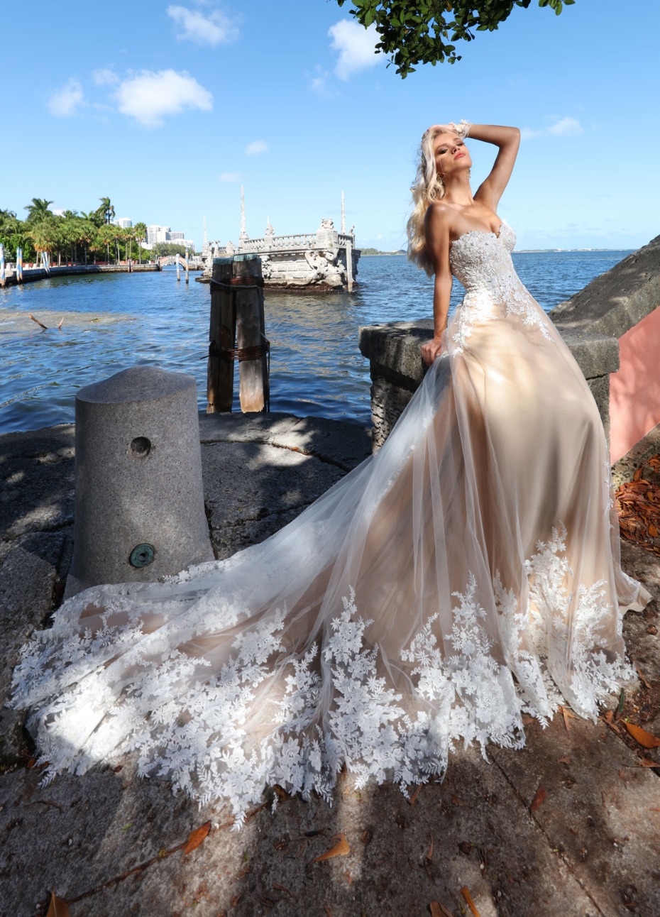 Stunning bride in lace wedding gown by the sea