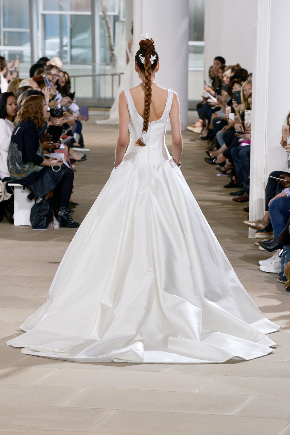 Bride in stunning white gown walks runway show back view