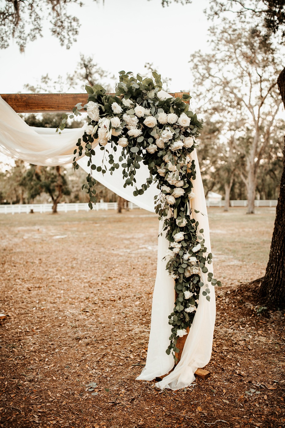 Floral wedding arch with draped fabric