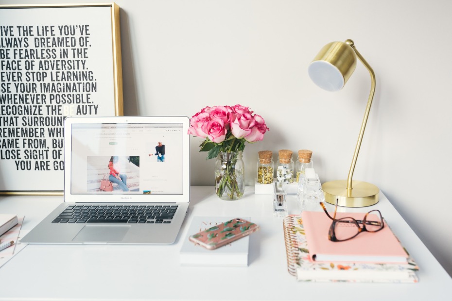 Stylish workspace with laptop, flowers, and gold lamp