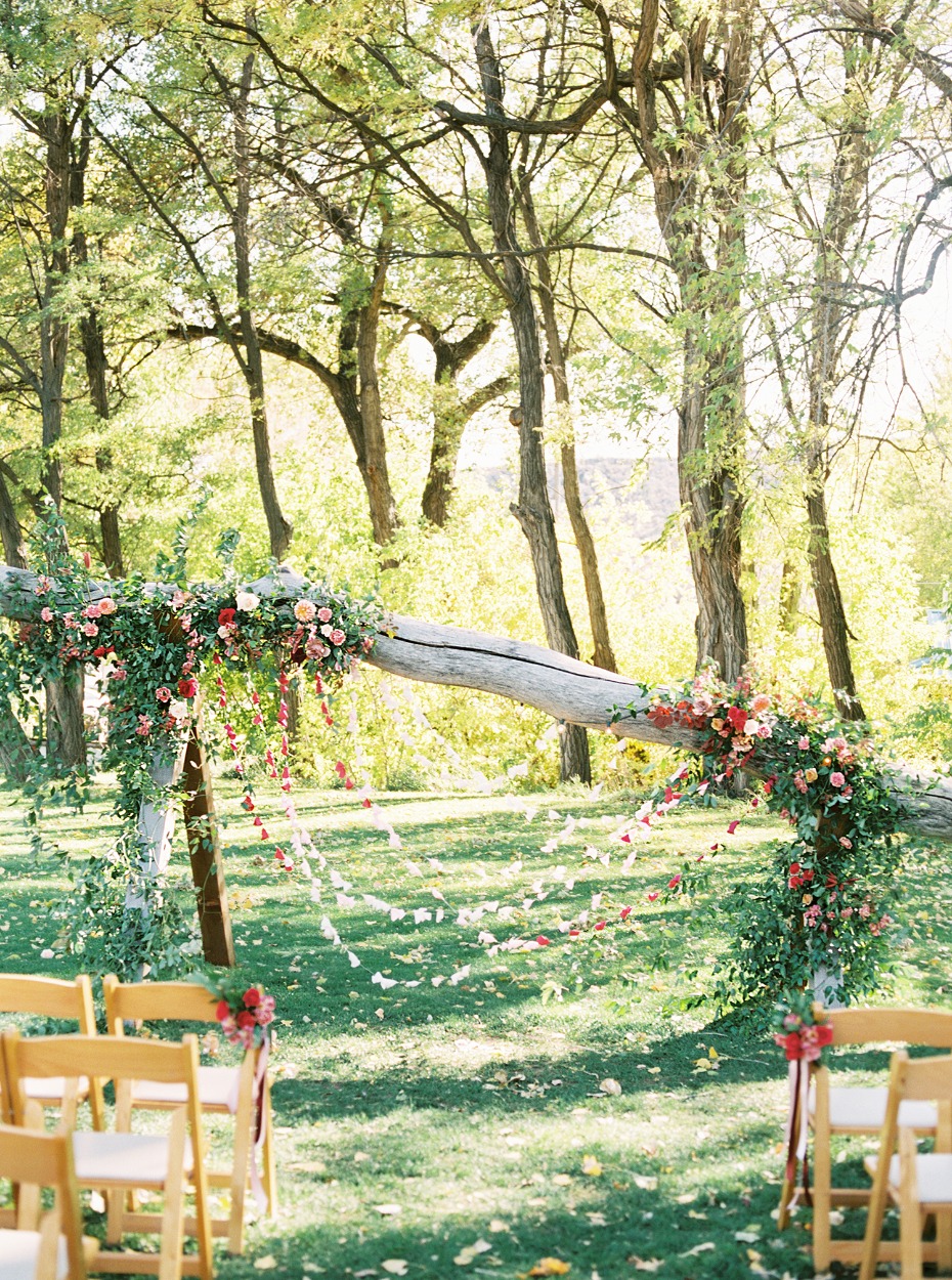 leaning bleached tree with cascading floral decor and paper backdrop