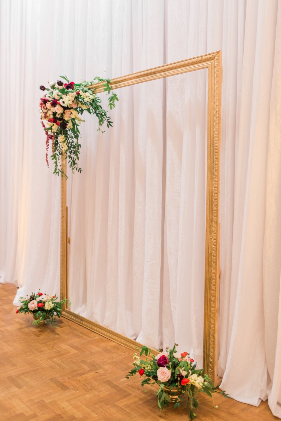 gold wedding backdrop mimics a frame for a painting