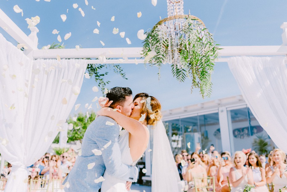 wedding kiss with flower petal confetti