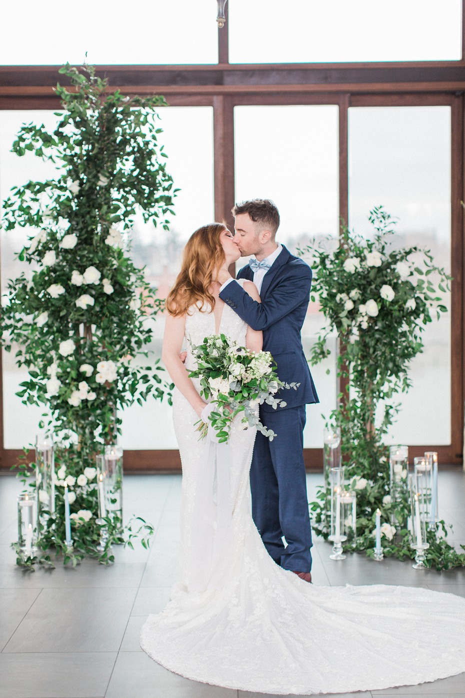 romantic wedding kiss with asymmetrical floral backdrop