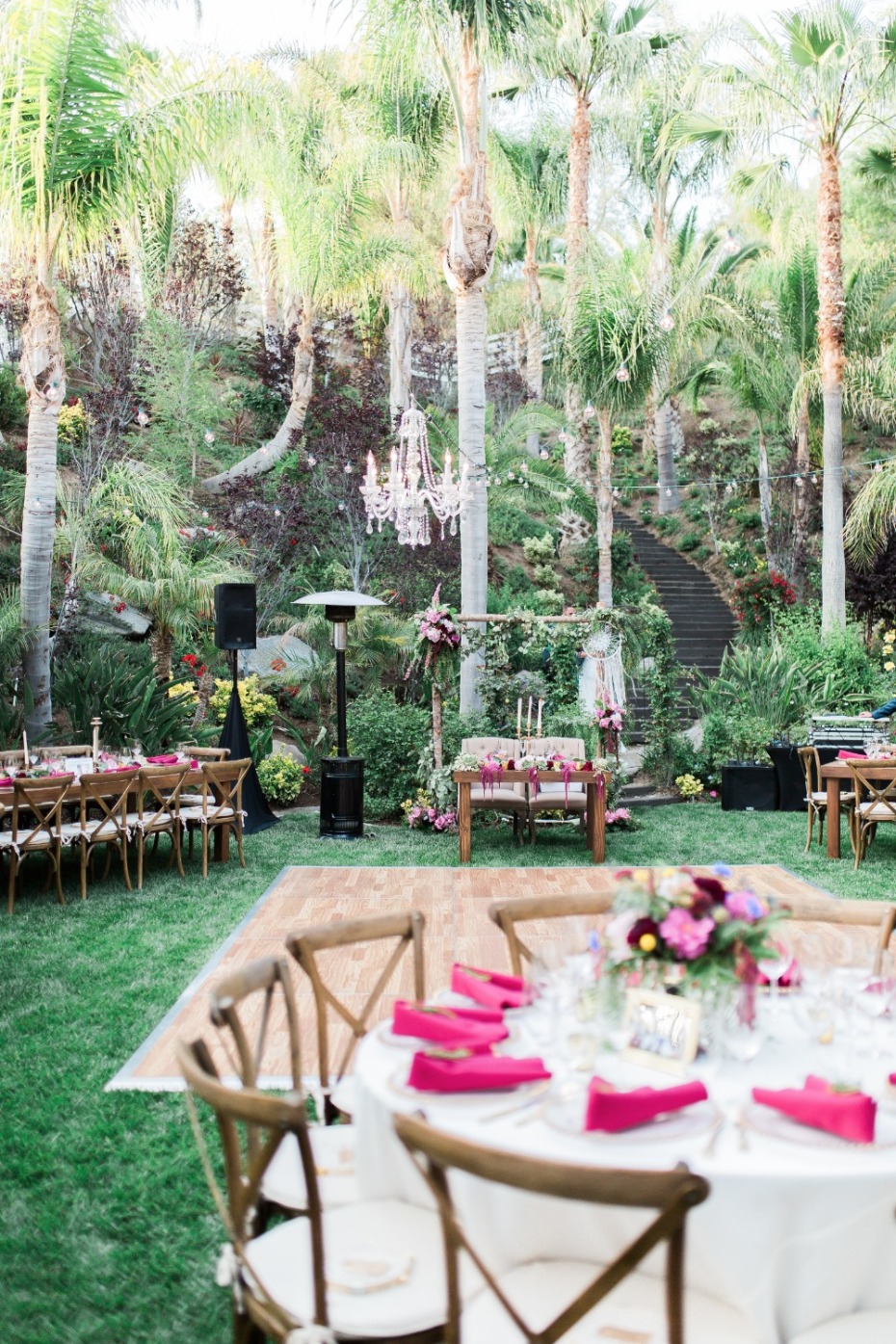 Outdoor wedding reception with rustic charm under palm trees
