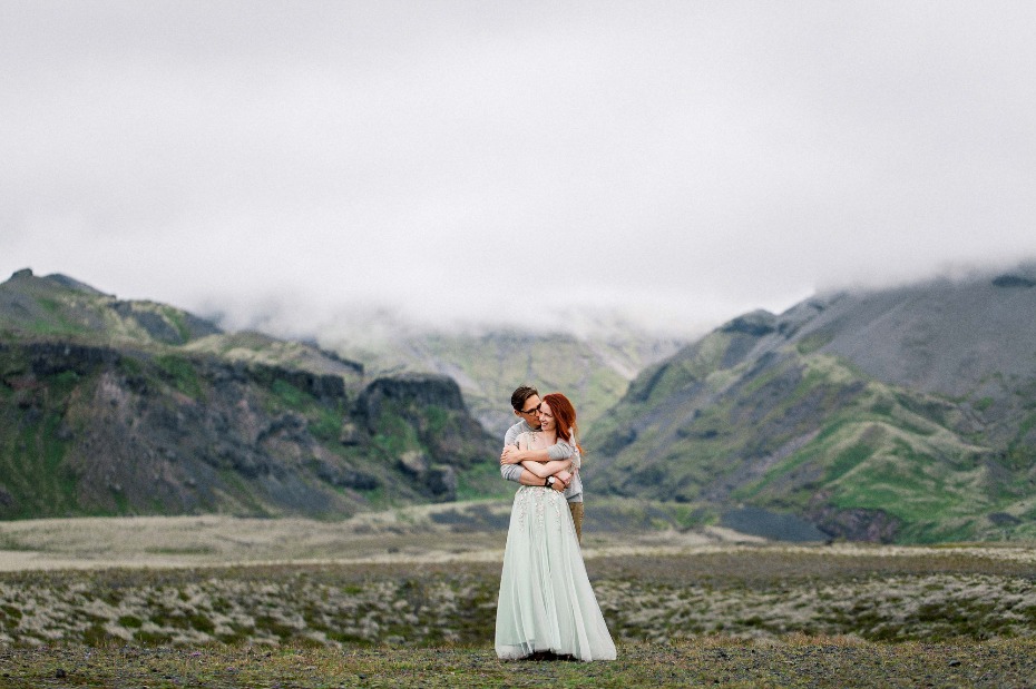 Couple embraces in majestic mountains, engagement portrait