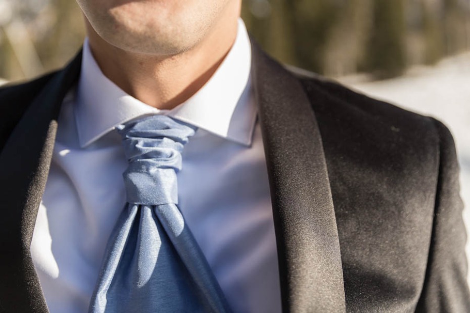 groom in black velvet and cravat style ice blue tie
