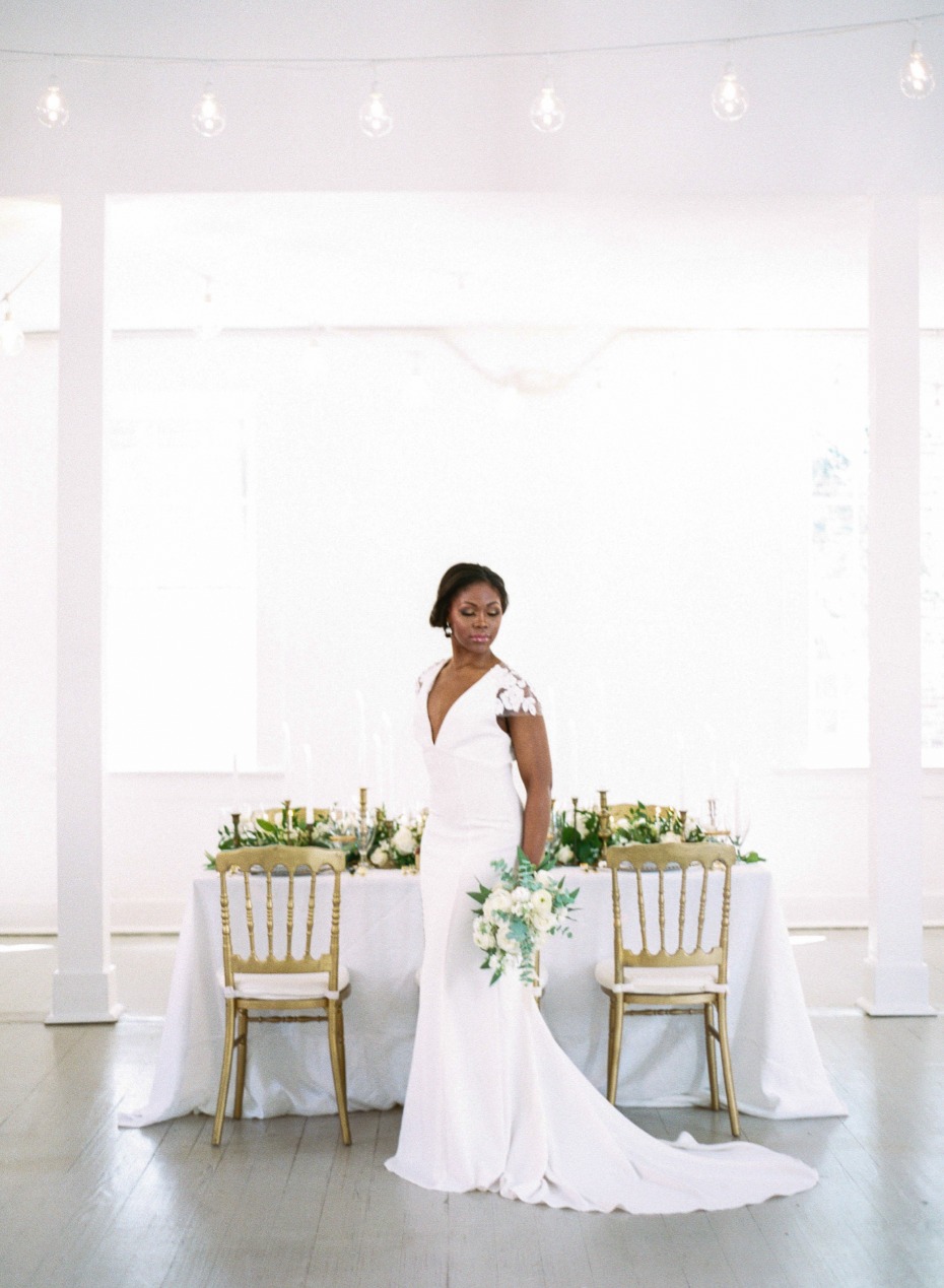 bride with her gold and white wedding decor