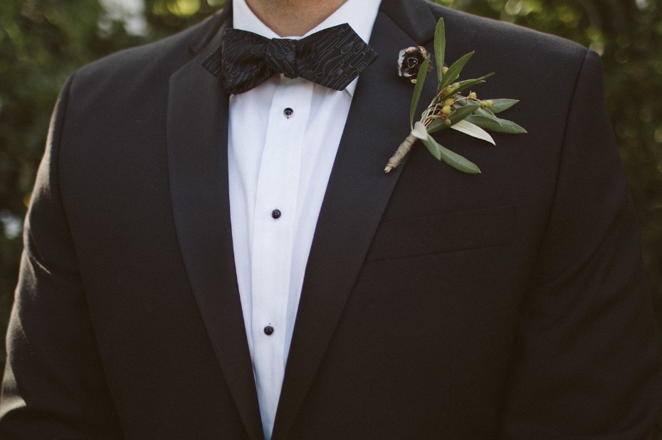 black tie groom style with a fun knife and fork patterned bow tie