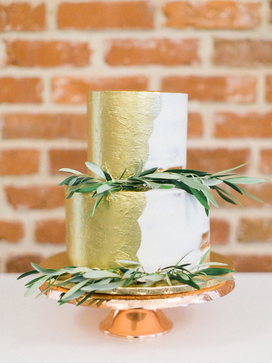 gold and white cake with greenery