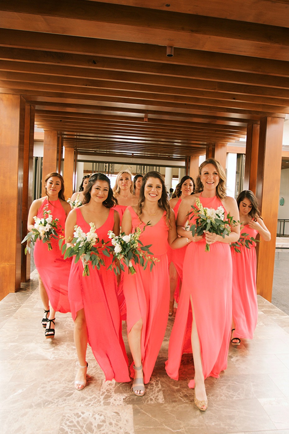 here comes the bridesmaids in hibiscus colored dresses
