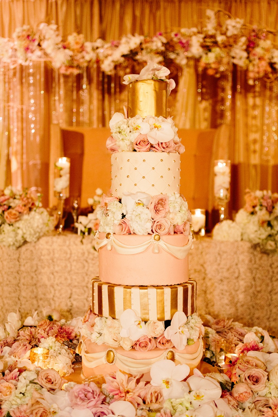 Gold white and blush wedding cake and flowers