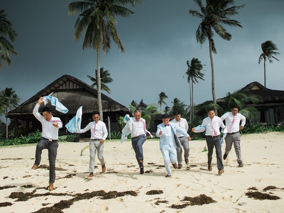 groom and his men having a blast on the beach