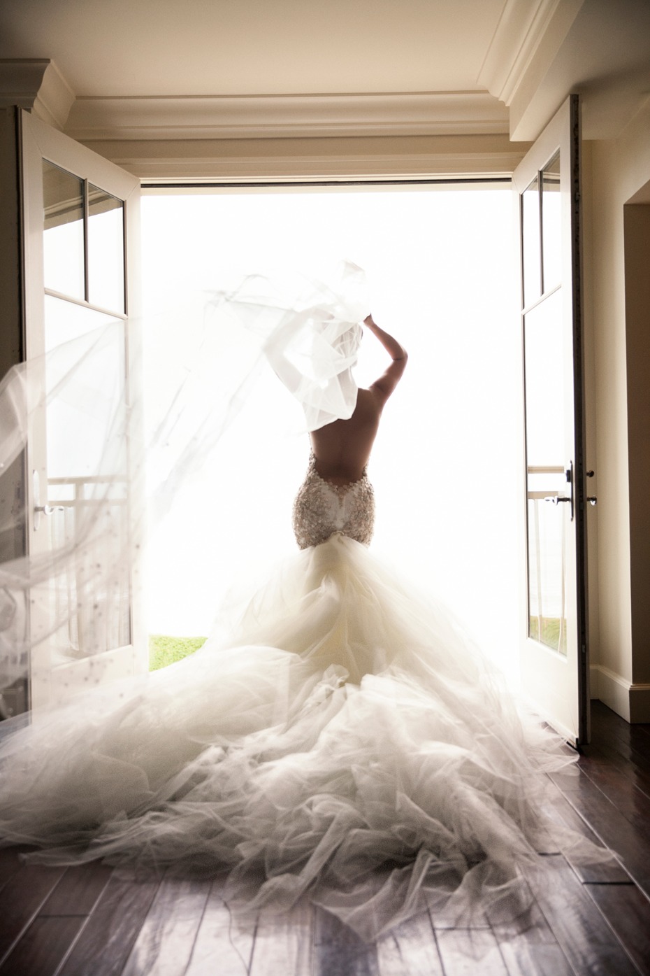 Bride in elegant wedding dress with veil blowing in the wind