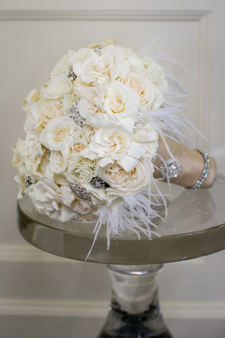 Elegant white rose bridal bouquet with feathers and jewels