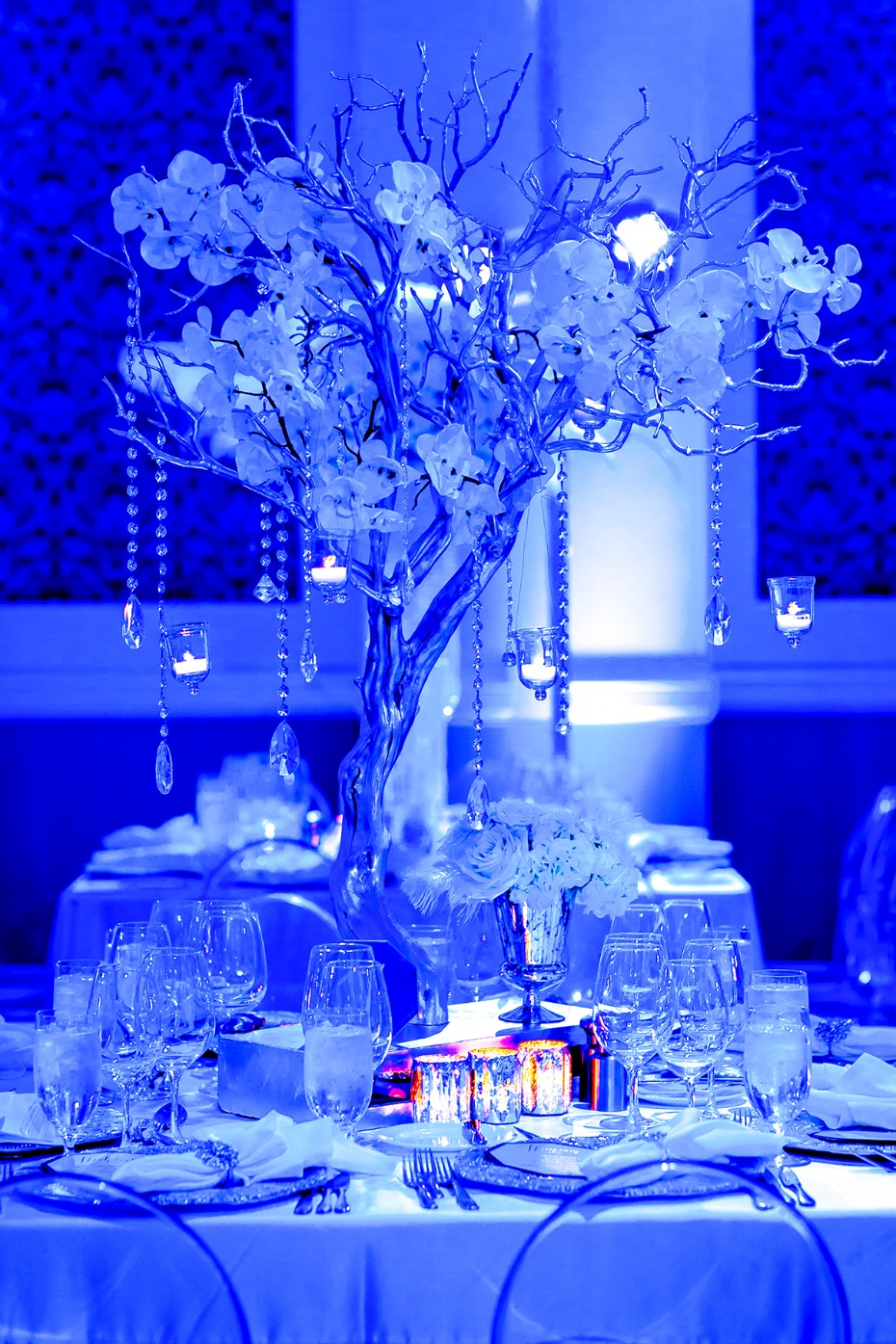 Elegant wedding table setting with a blue floral centerpiece
