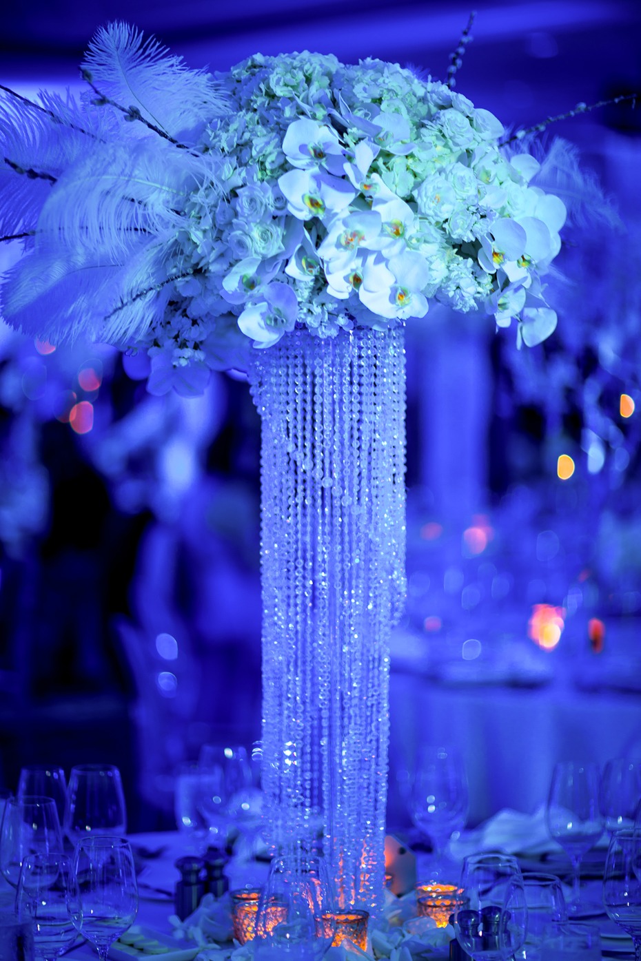 Elegant floral centerpiece with crystals and feathers on a table