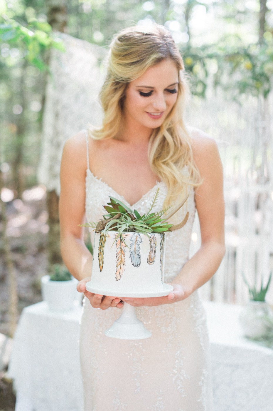 Mini cake with feathers and greenery topper