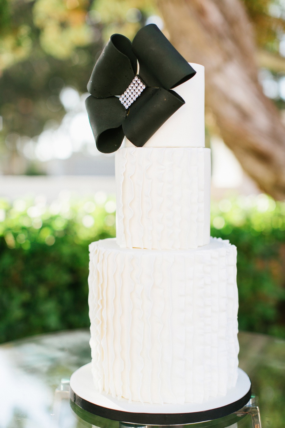 Modern white ruffle cake with black bow