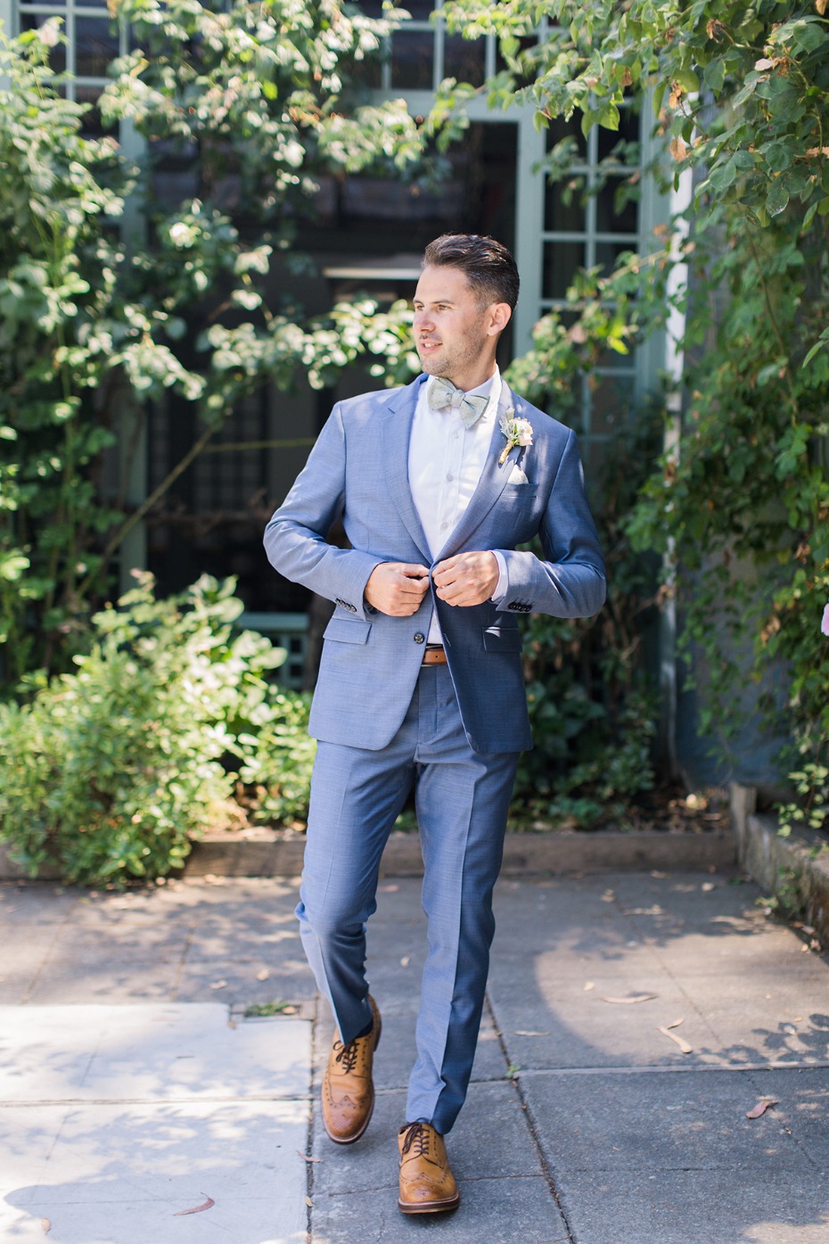 groom in blue grey suite with sage bow tie