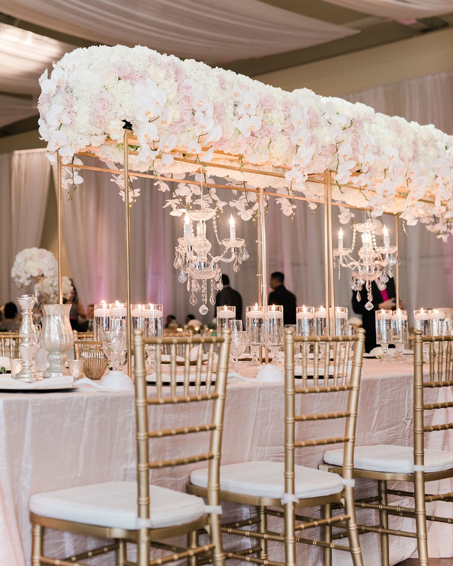gold and white wedding decor with table halo and chandeliers