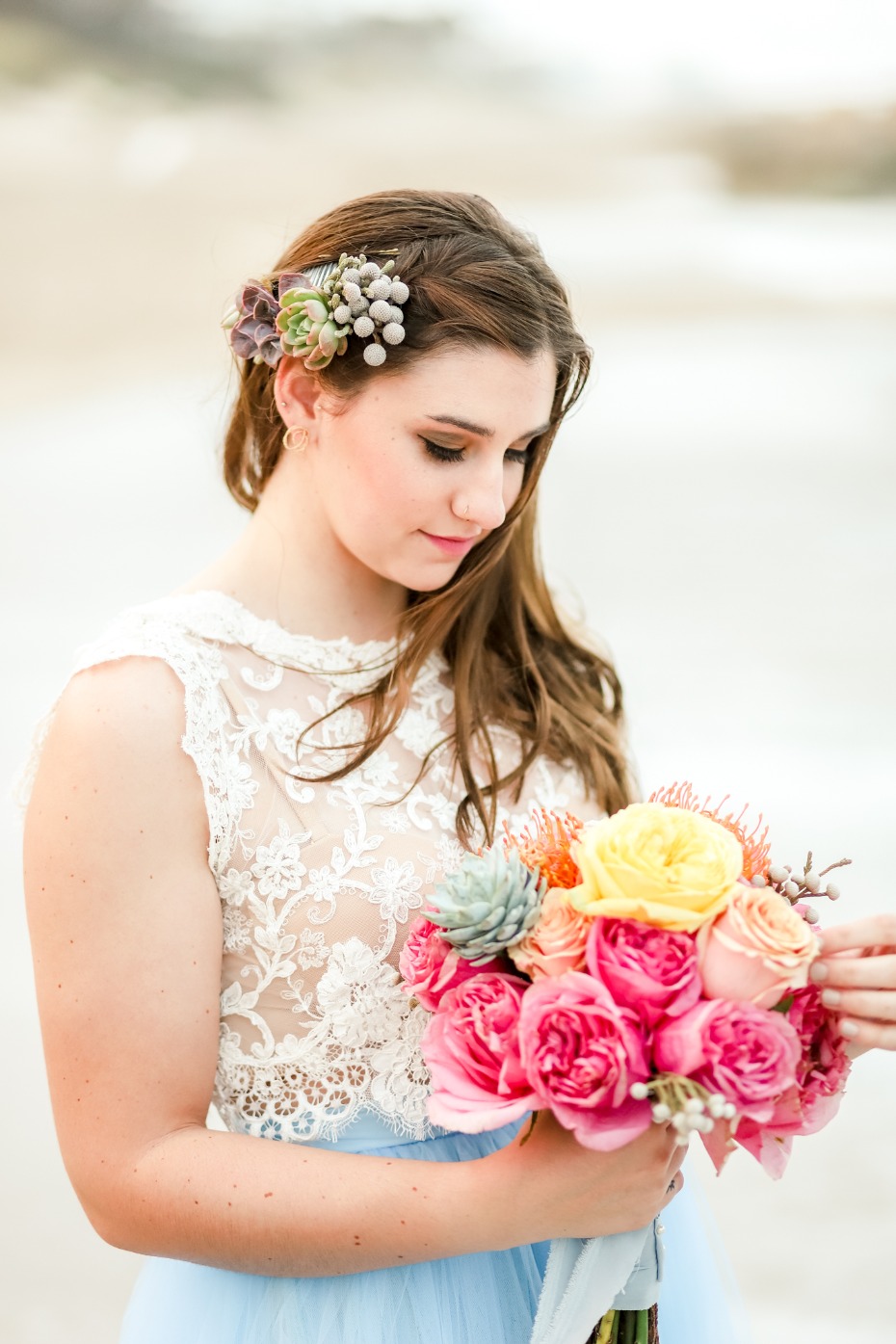 Bride holding a colorful bouquet with floral hair accessory in her hair
