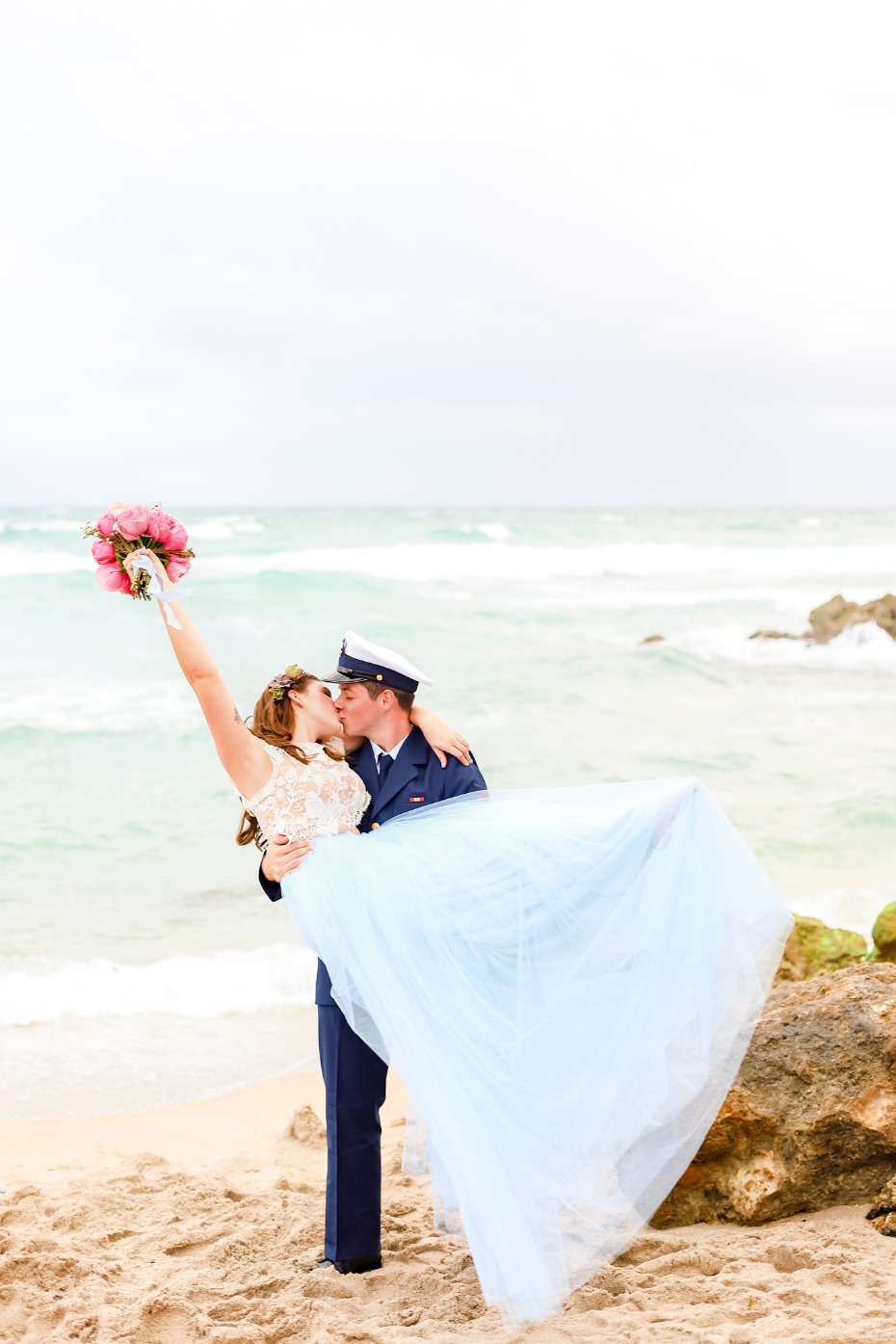 Bride and Groom kissing on a beach at wedding, ocean background