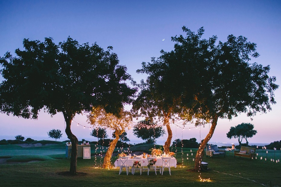 Romantic outdoor dinner party under string lights trees