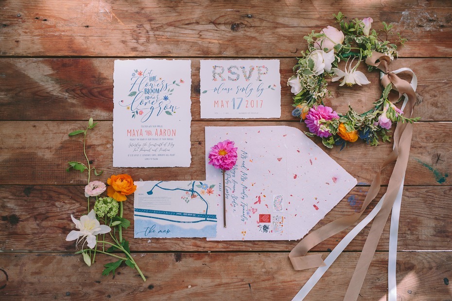 Wedding invitation suite with floral wreath on wood
