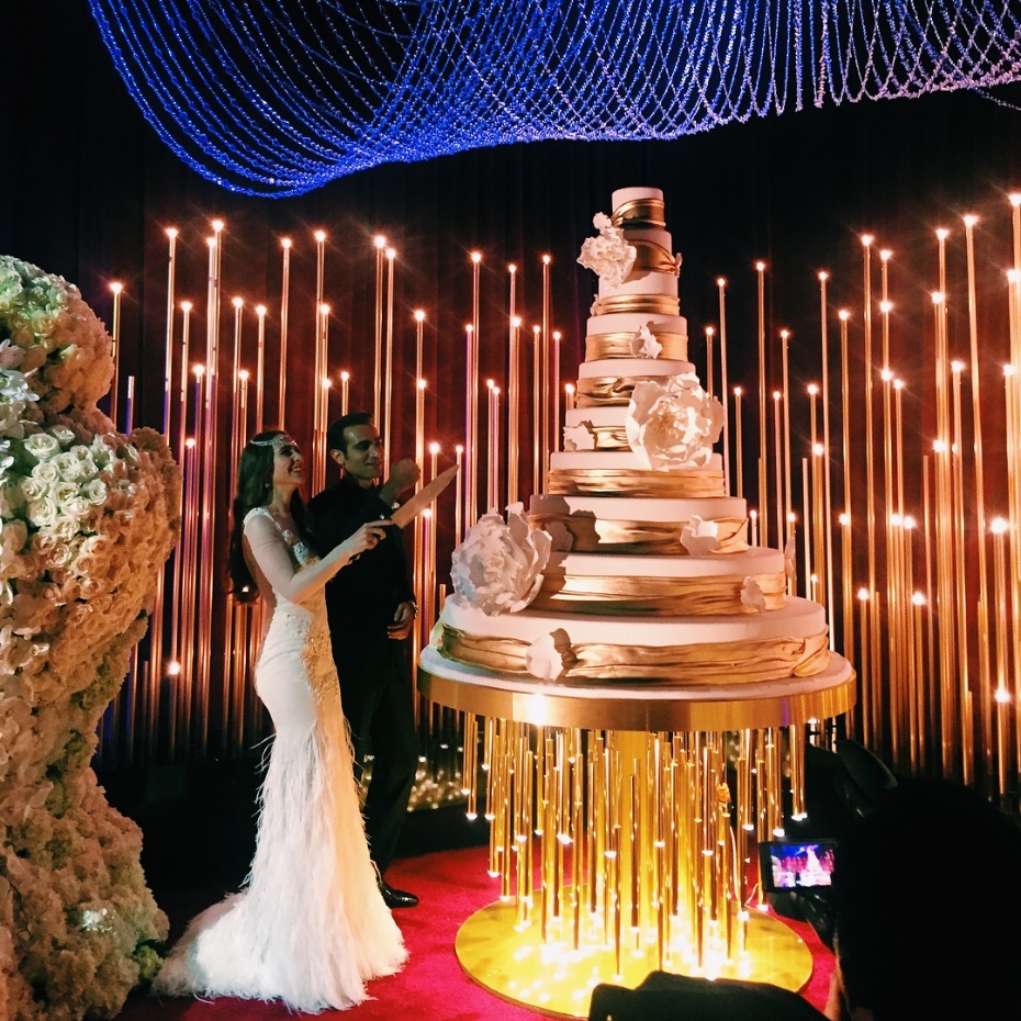 Stunning wedding couple cutting a magnificent tiered cake