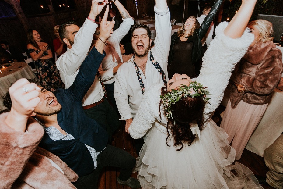Joyful wedding guests dance with bride