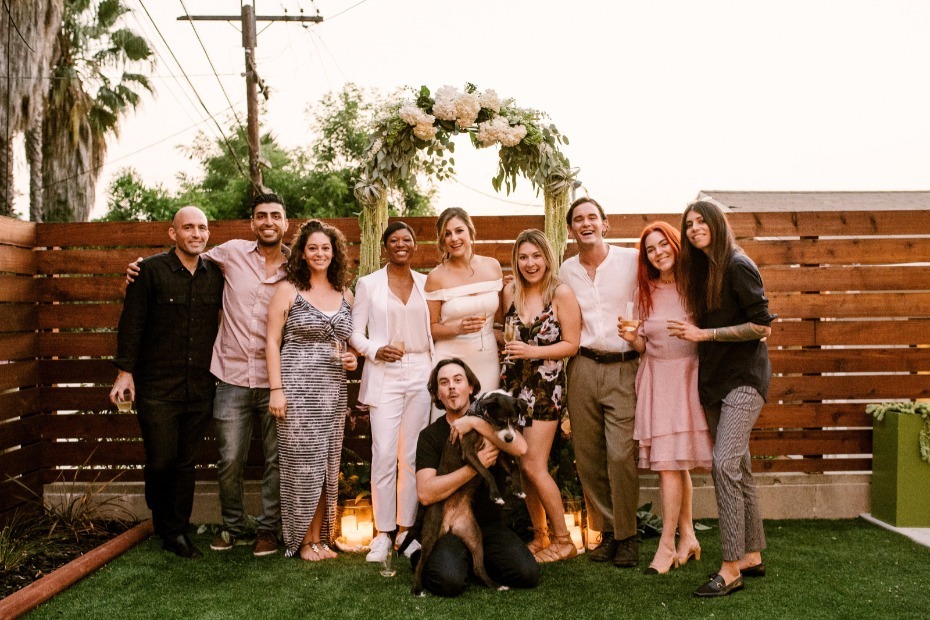 Friends celebrating wedding with champagne and dog