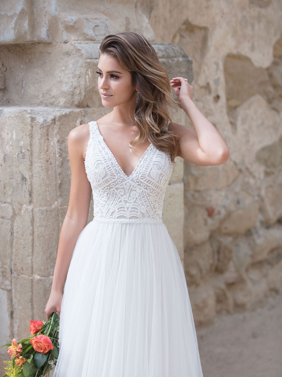 Bride in a lace bodice tulle wedding dress holding flowers