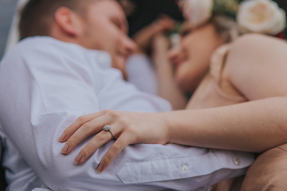 Engaged couple embracing, showing off the engagement ring