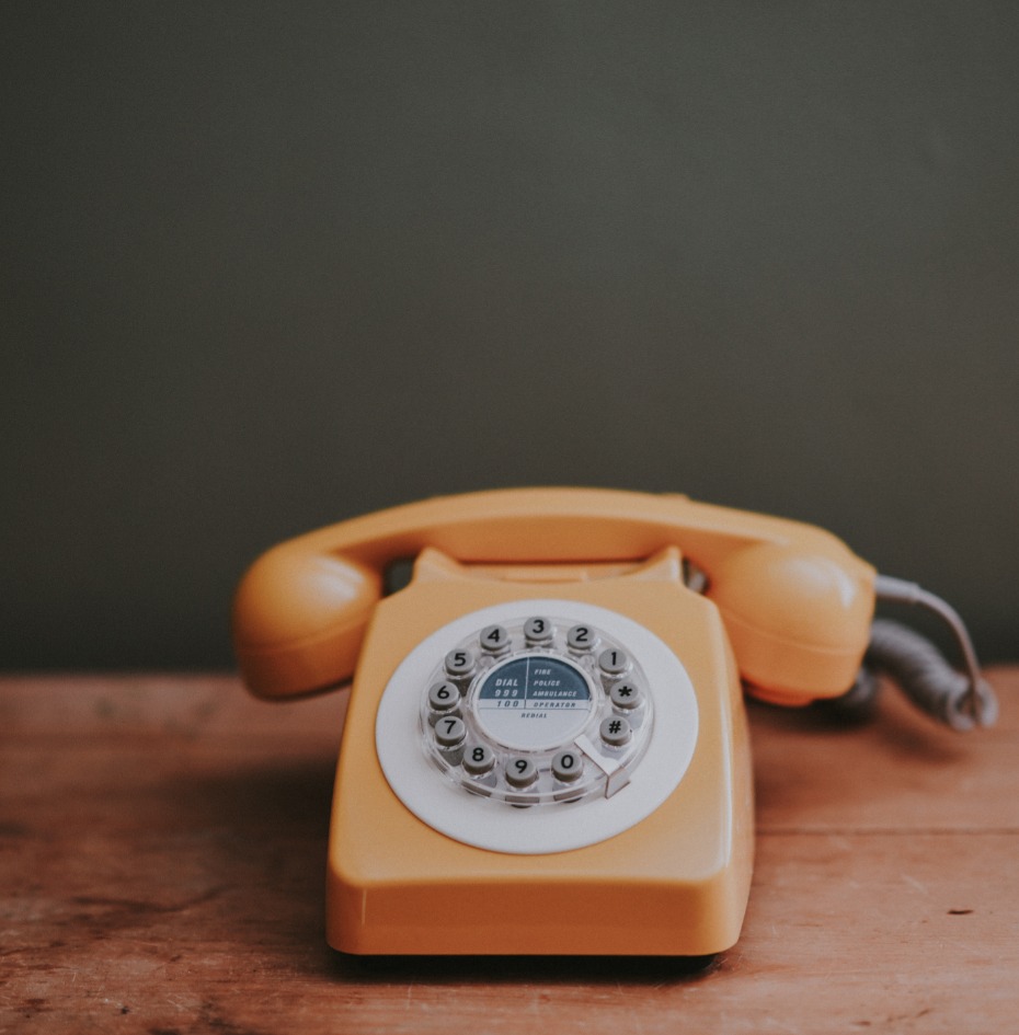 Vintage rotary phone on wooden surface