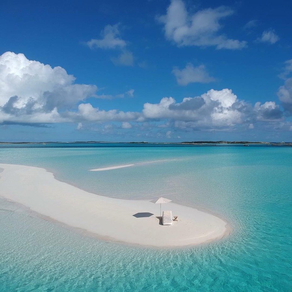 White sand beach paradise with lounge chair and umbrella