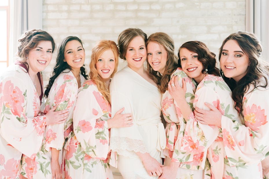Bride and bridesmaids in floral robes smiling together