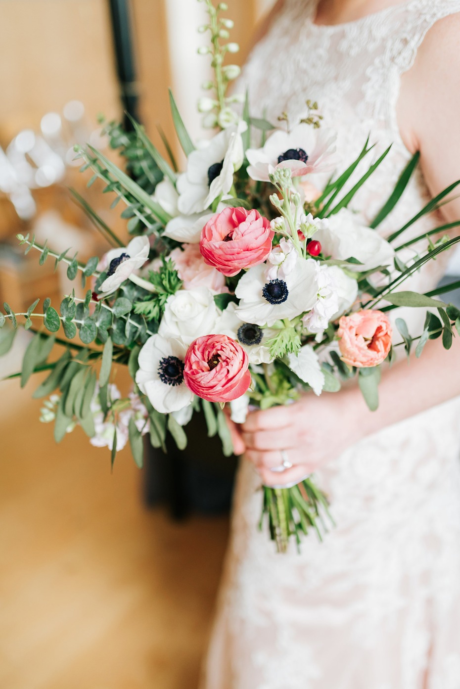 Bride holding a floral bouquet with white anemones