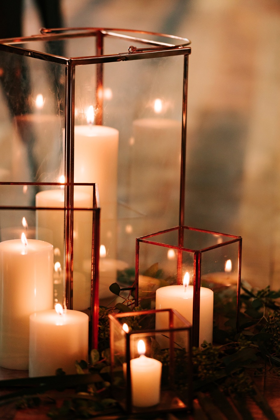 Elegant candles in glass and copper geometric lanterns