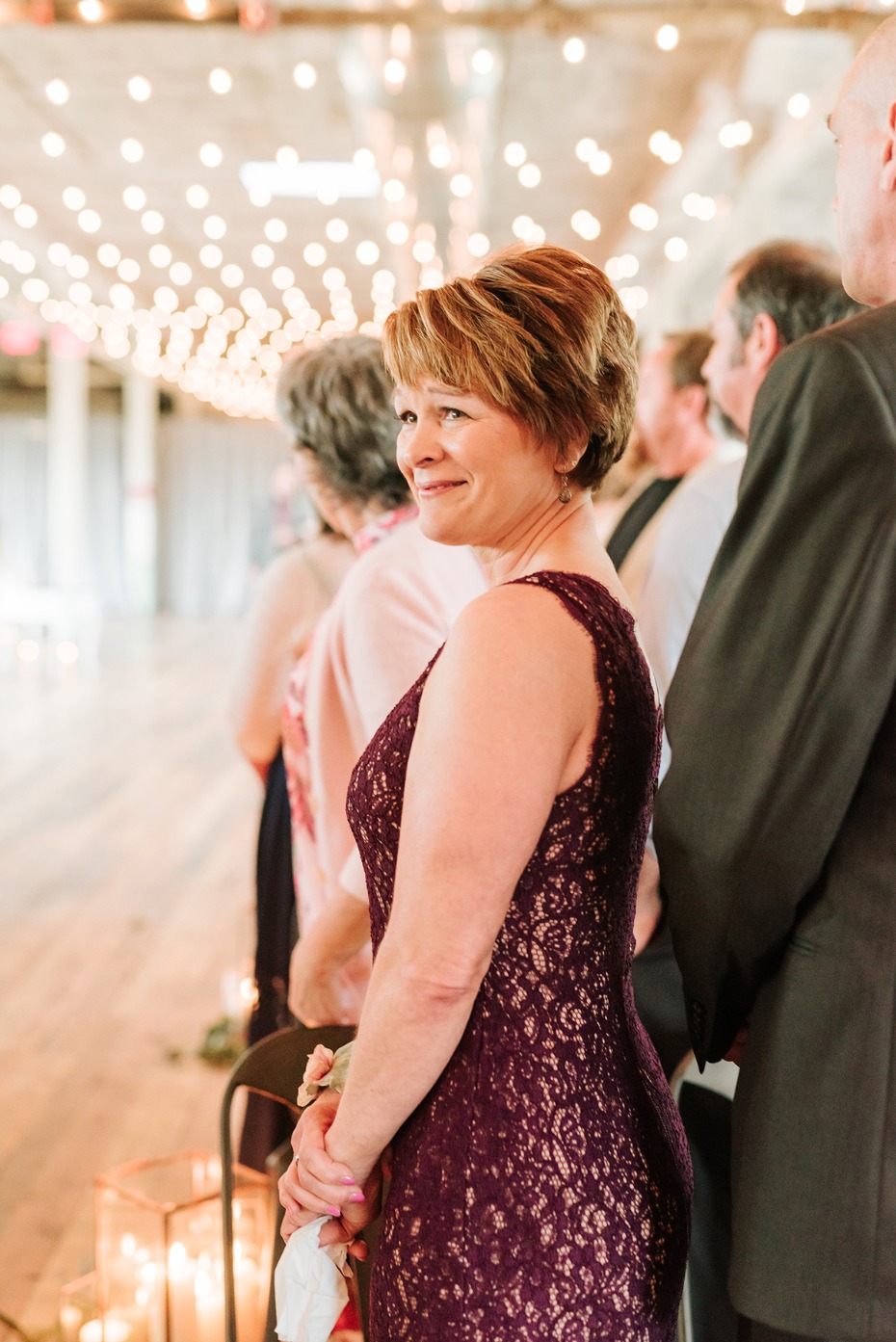 Woman in lace dress at wedding looking back smiling