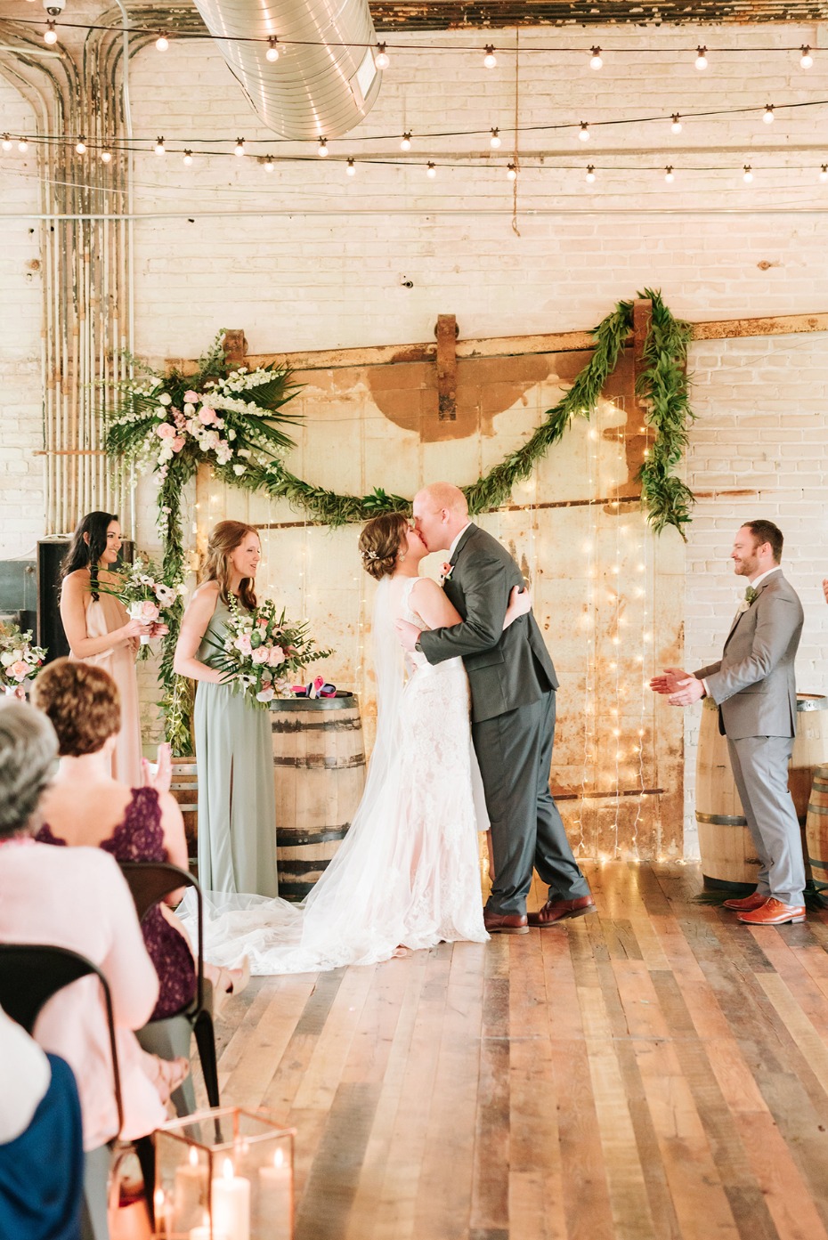 Bride and groom share first kiss at industrial wedding