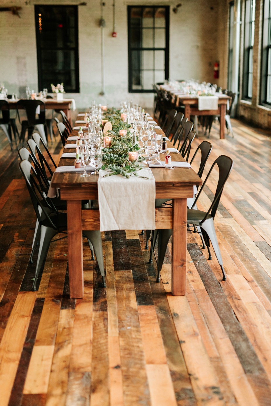 Rustic wood tables set for a wedding reception venue