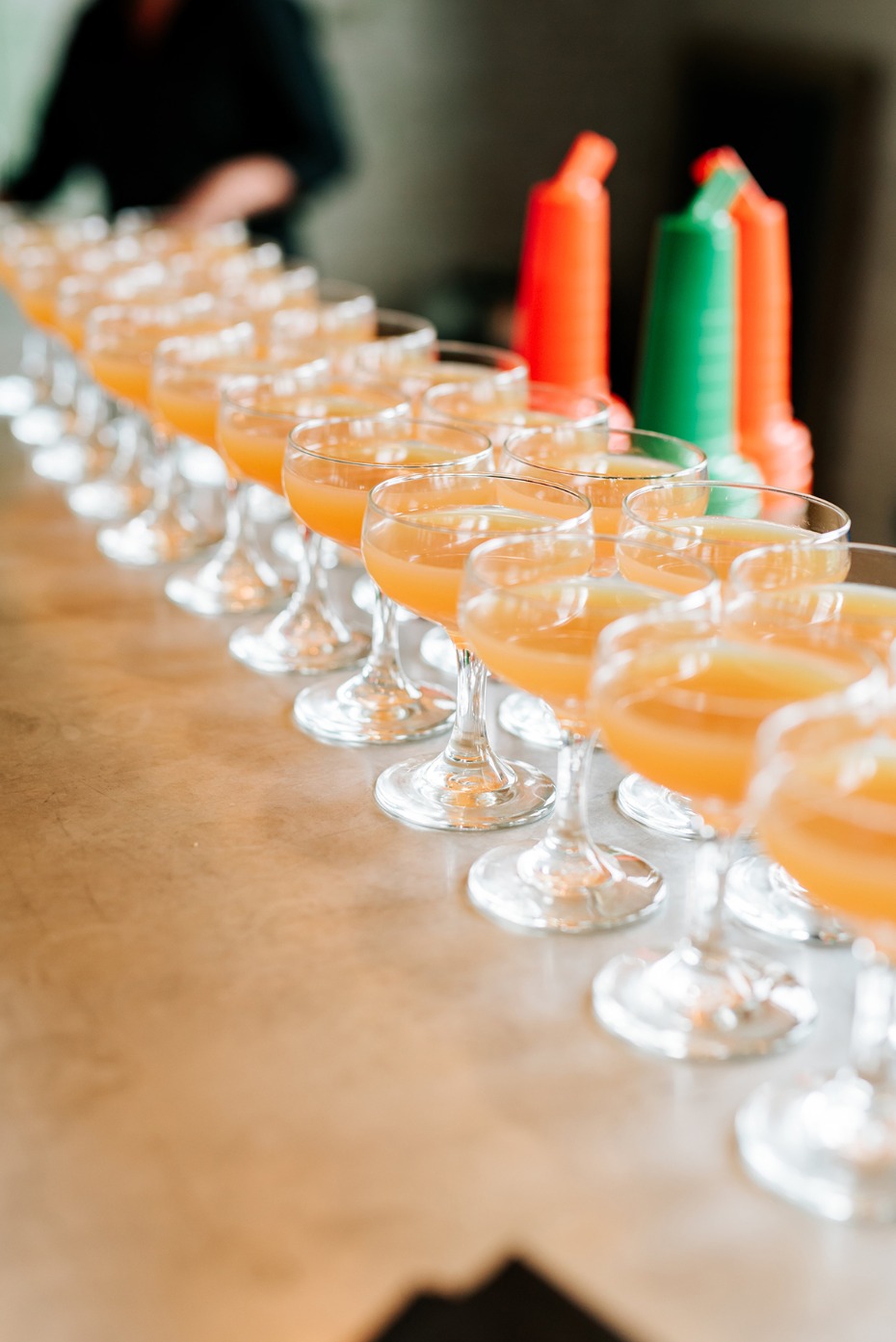 Row of elegant cocktail glasses filled with orange drinks