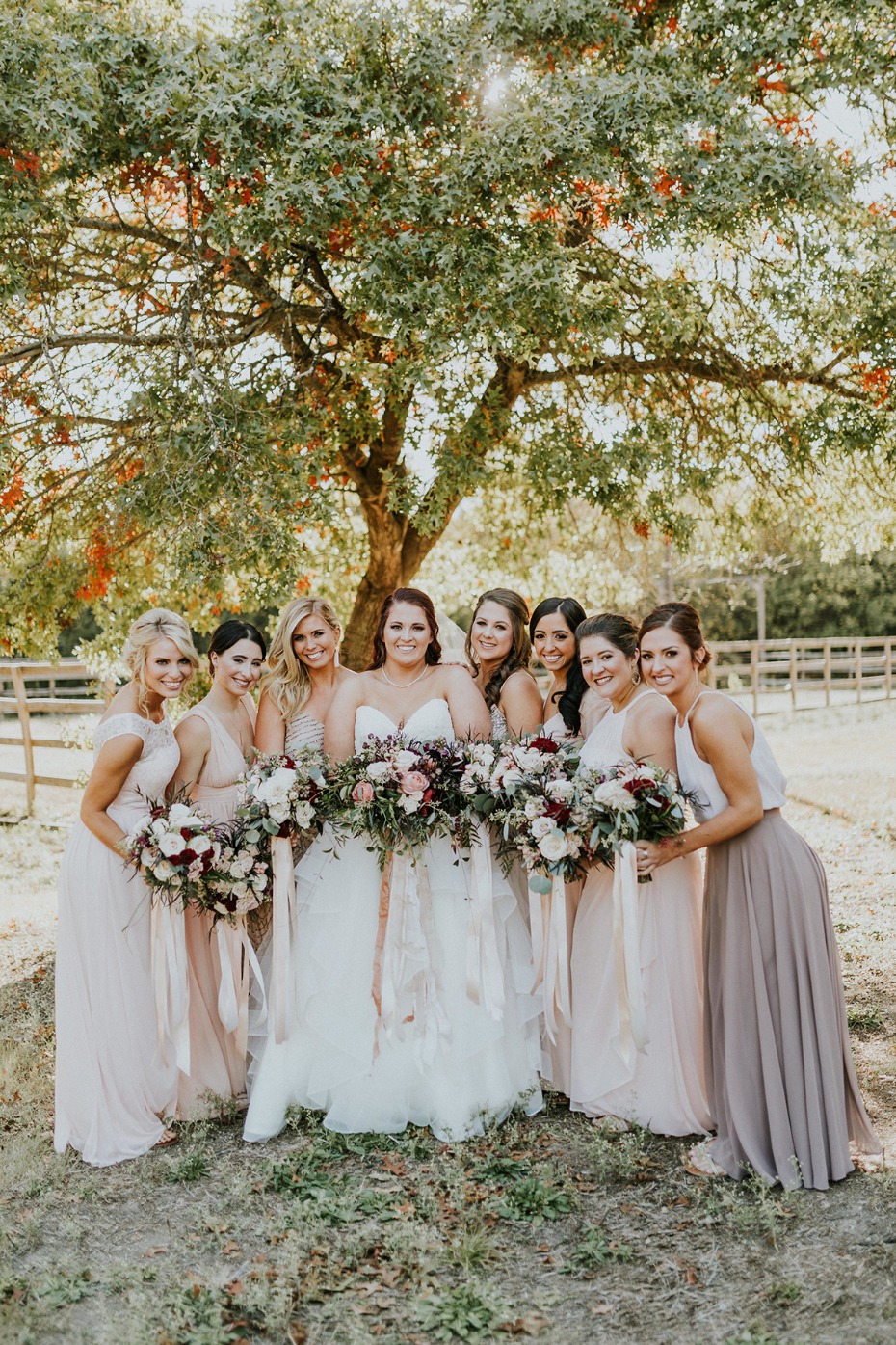 Bride and bridesmaids in flowing gowns with bouquets