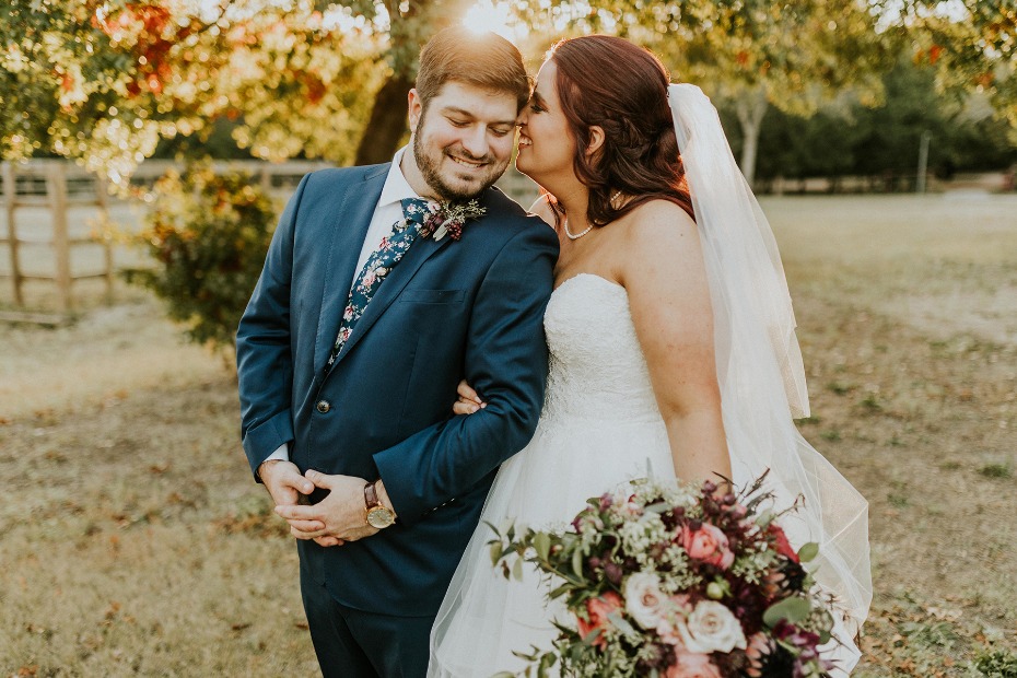 Bride whispering to smiling groom on their wedding day