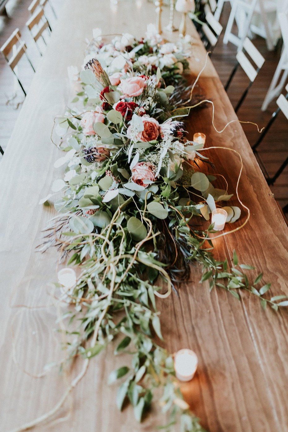 Romantic table decor with lush floral runner and candles